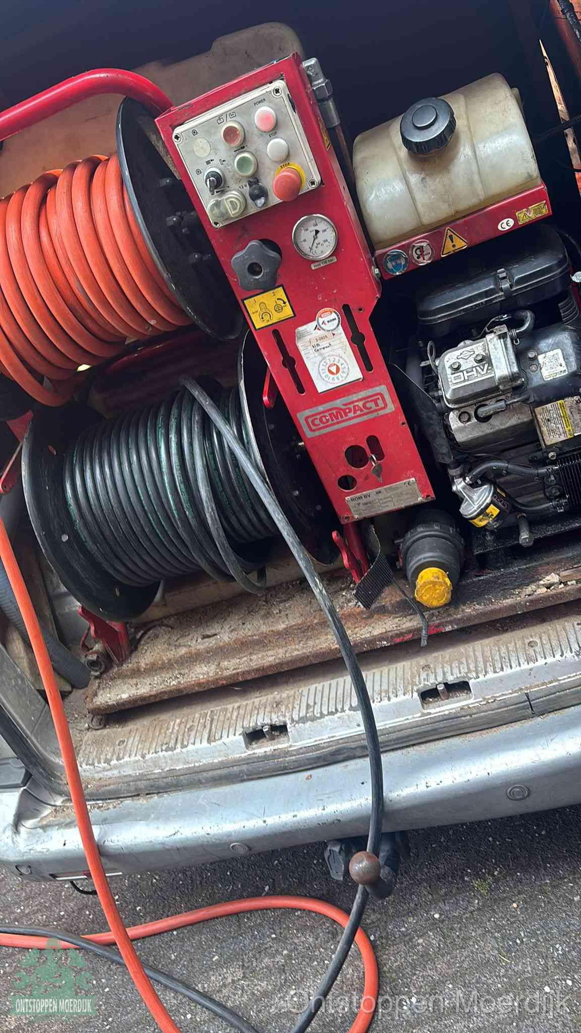 Een rood hogedruk-rioolreinigingstoestel in de laadbak van de bedrijfsbus, apparatuur voor een hardnekkige afvoerverstopping in Moerdijk