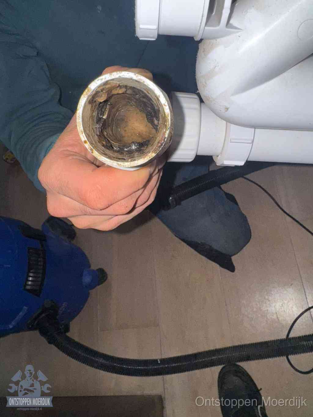 Een losgekoppelde afvoerbuis die van binnen volledig is dichtgeslibd met vet en aanslag, de meest voorkomende oorzaak van een verstopte gootsteen in Moerdijk