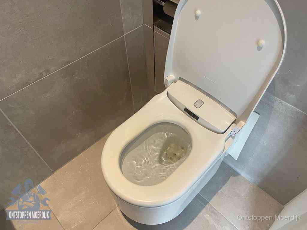Een toiletpot vol troebel water met drijvend papier en restanten, de meest voorkomende oorzaak van een verstopte wc in Moerdijk
